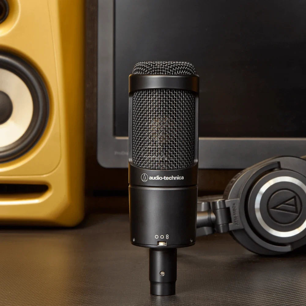 Black condenser microphone with metal mesh grille and base controls, front view