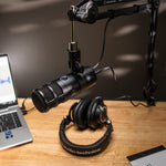 Dynamic podcast microphone with mesh grille and shock mount, cylindrical metal body