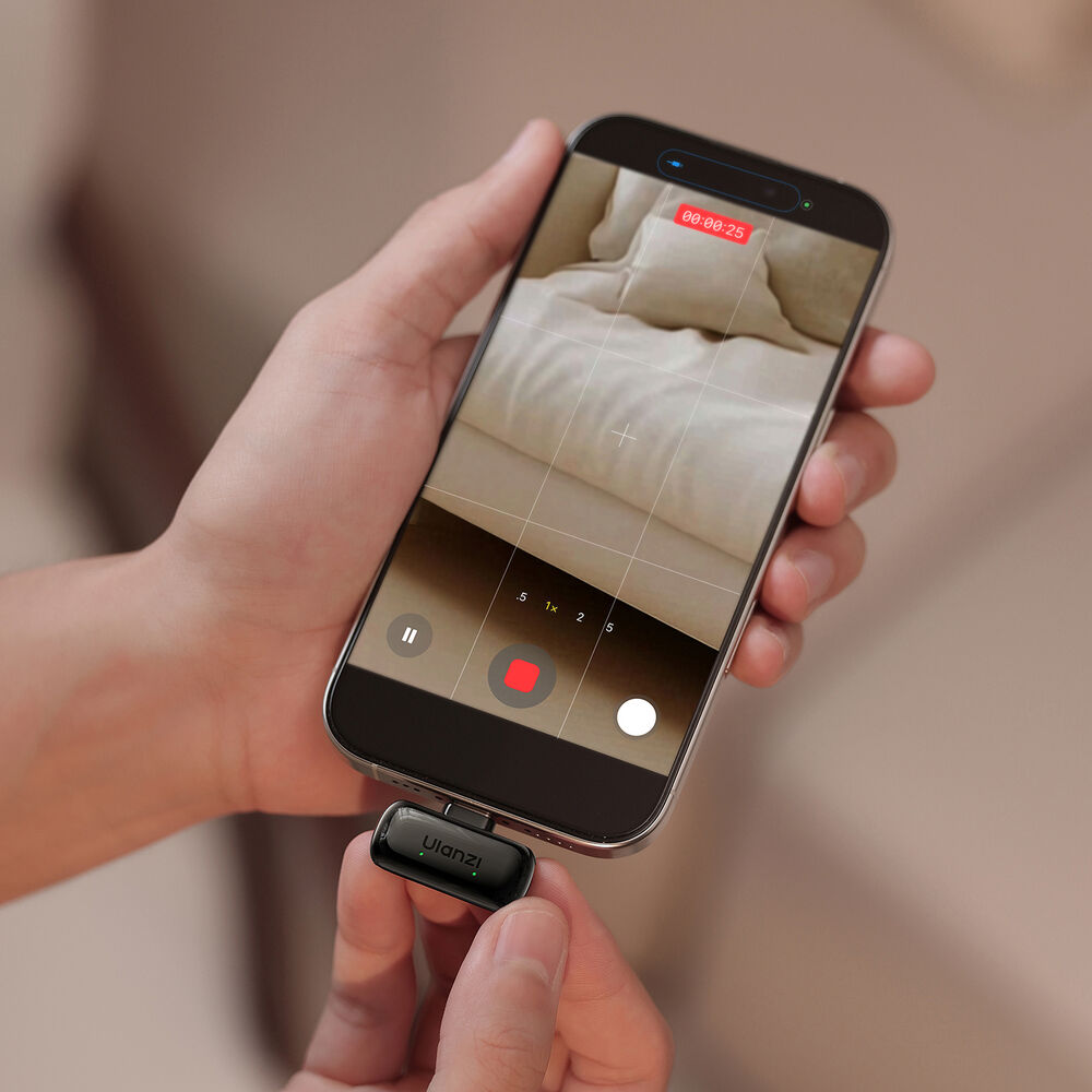 Hand holding a phone with wireless mini microphone attached showing recording screen
