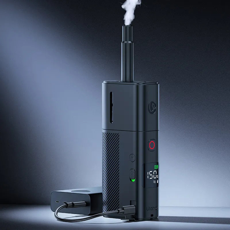 Black Ulanzi fog machine releasing a smoke plume from the top nozzle, standing with power cable.