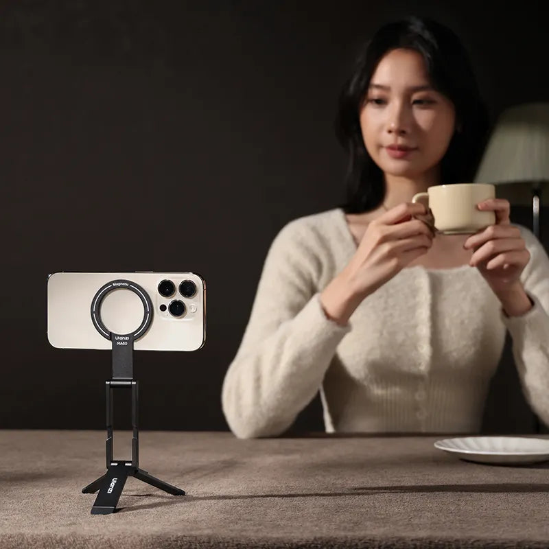 Foldable phone tripod stand holding a smartphone on a tabletop