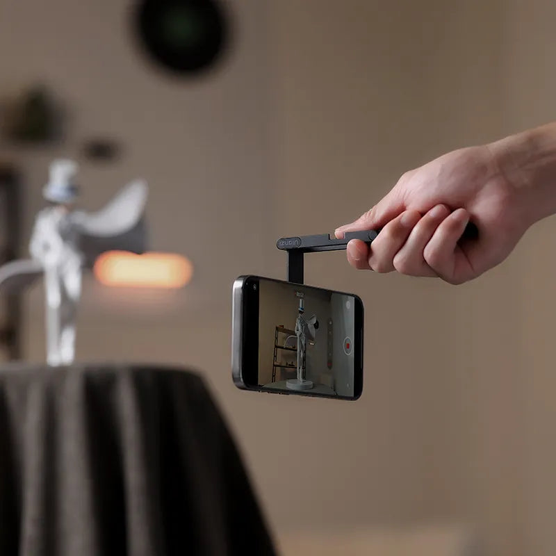 Foldable phone tripod clamp with smartphone mounted, ready to record