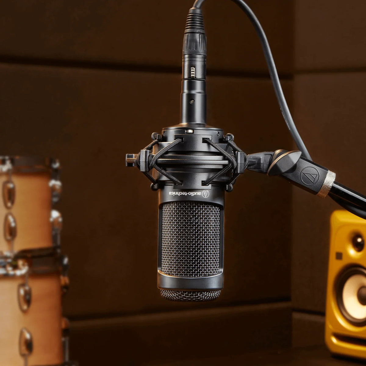 Condenser microphone in black shock mount with attached cable, center view