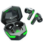 Black earbuds standing upright beside open charging case with green light bar